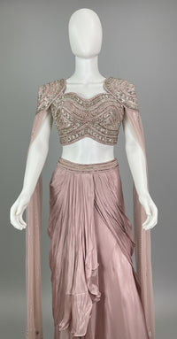 Mannequin wearing a mauve evening gown with intricate detailing against a dark background